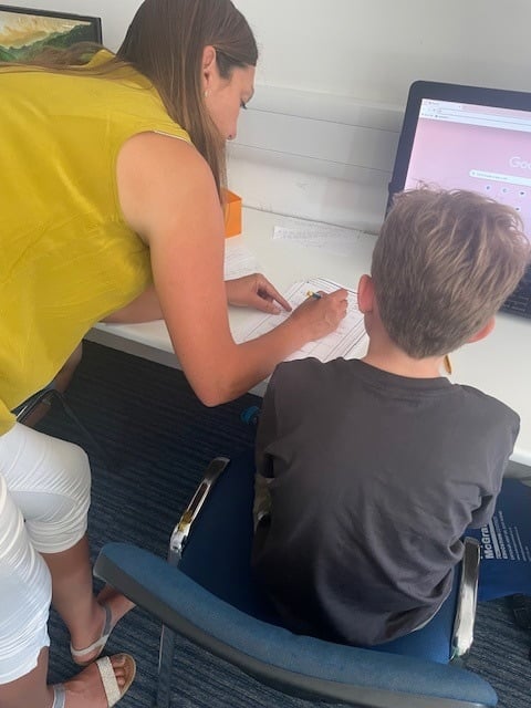 A qualified teacher working through a worksheet one to one with a child at the centre